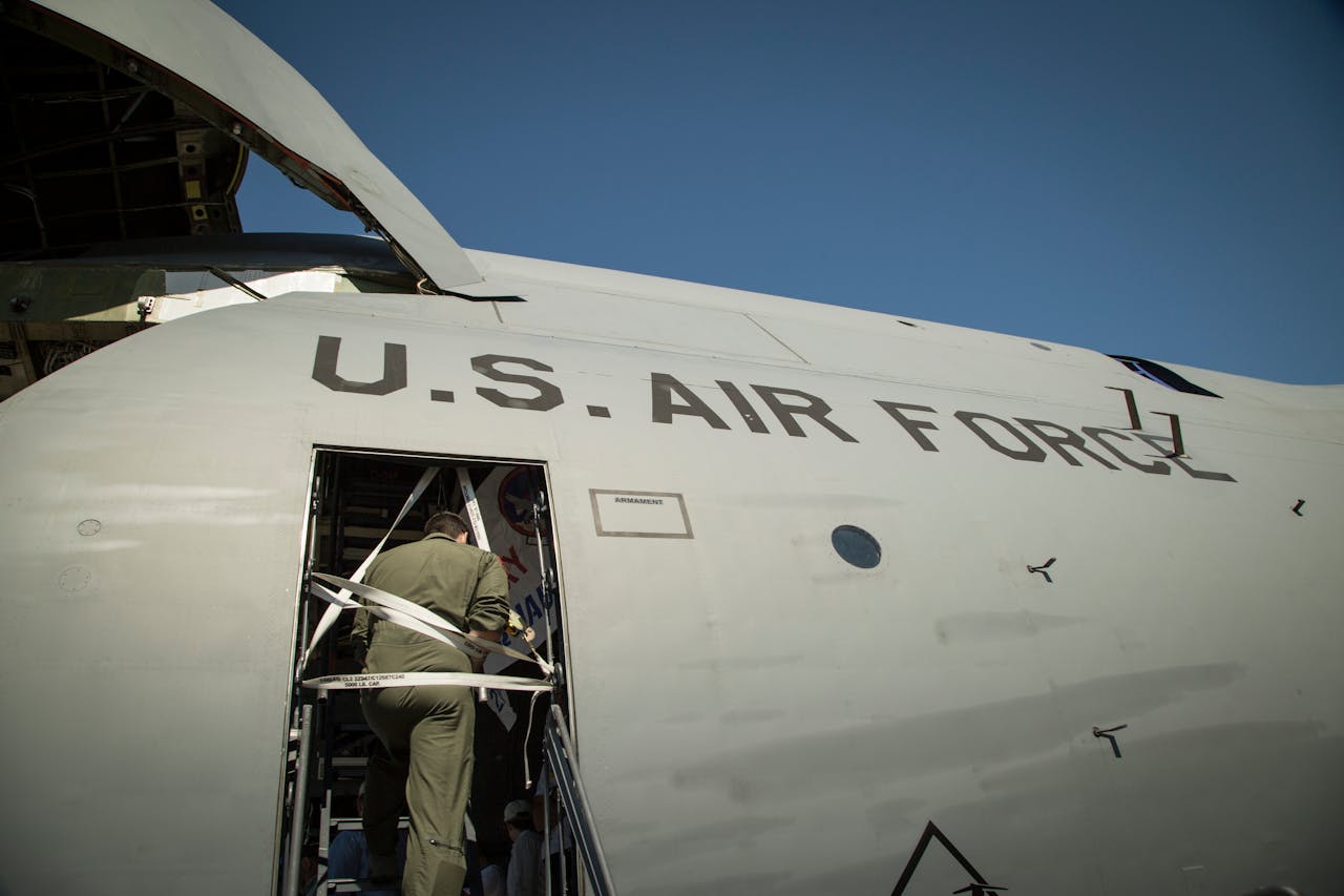 US Air Force personnel loading cargo into a military transport aircraft.